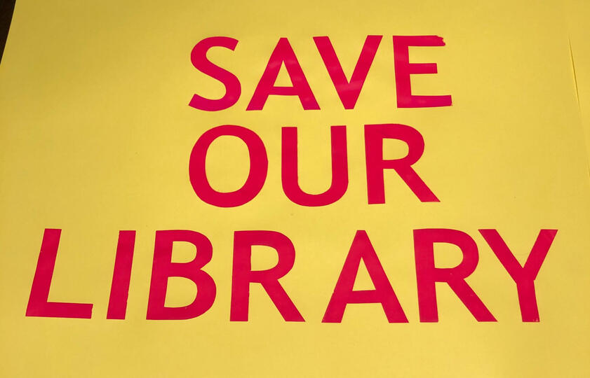 Yellow background with pink text saying 'save our library'