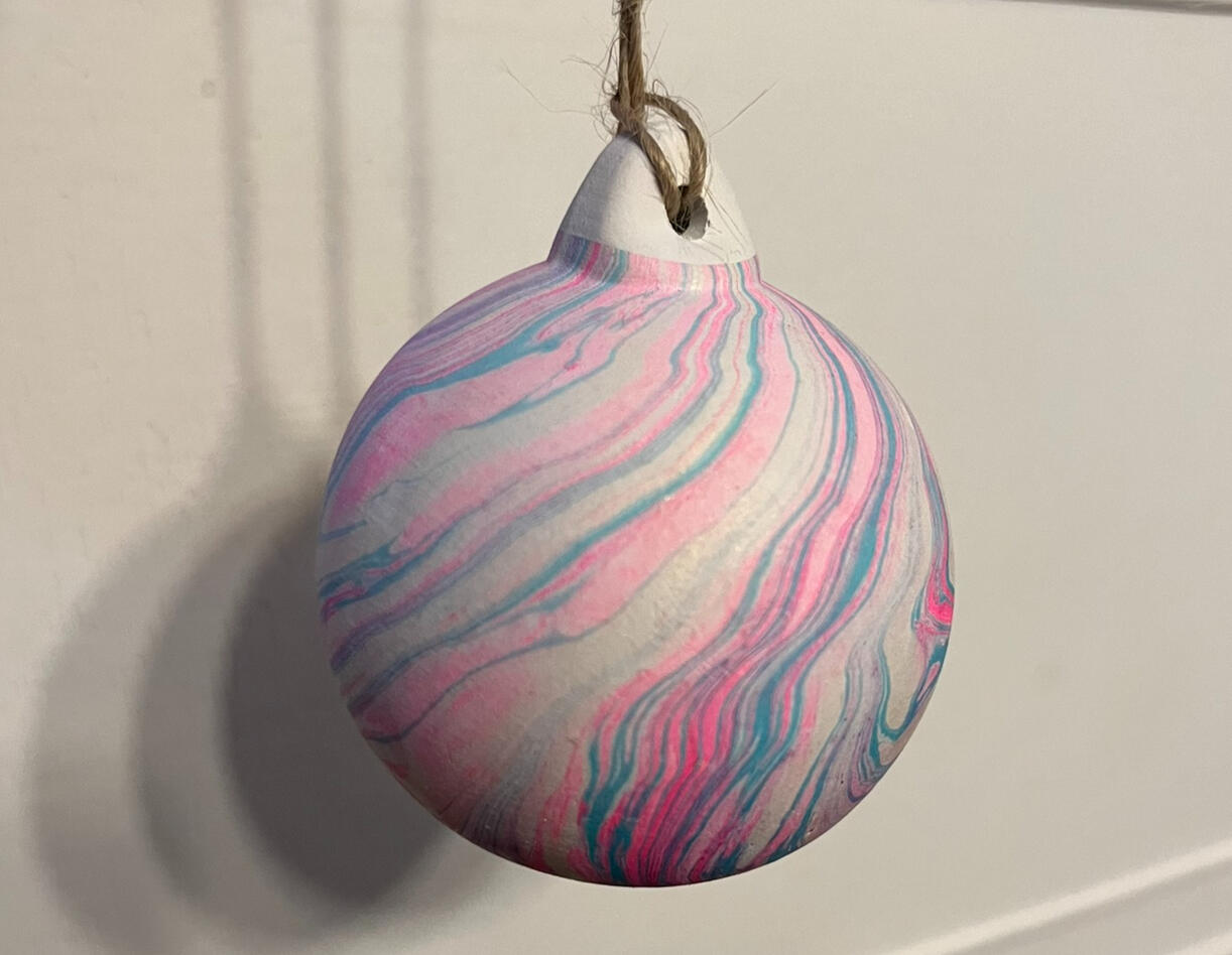 Hand dipped ceramic bauble - white bauble with pink and blue ink in swirling patterns.